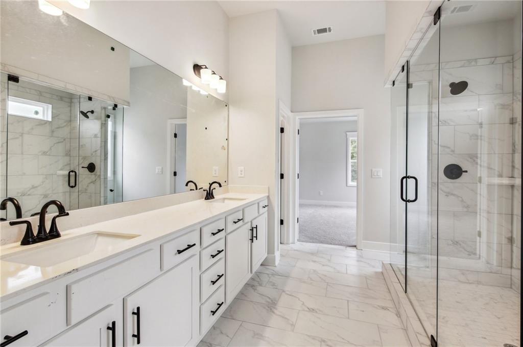 368 Scarlet Rose Way Hoschton, GA 30548 - Photo 41 of 150 a bathroom with a double vanity sink a large mirror and shower