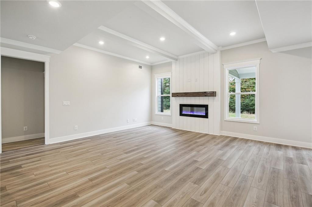 368 Scarlet Rose Way Hoschton, GA 30548 - Photo 7 of 150 an empty room with wooden floor fireplace and windows