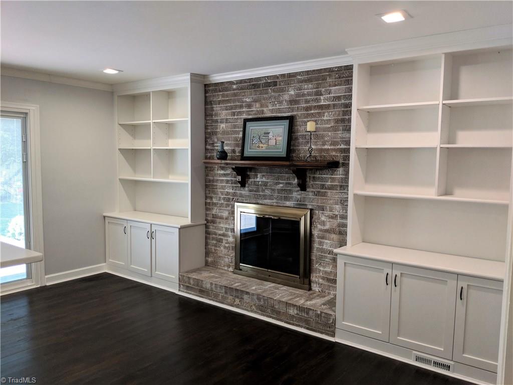 550 Pepperidge Road Lewisville, NC 27023 - Photo 8 of 30 Den updated with gorgeous custom book cases and cabinets for storage. Gas logs in place, never used, but hook-up available for propane. Whitewashed fireplace and dark wide plank hardwoods add warmth against the crisp walls.