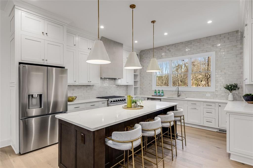 224 Pindos Place Southwest Powder Springs, GA 30127 - Photo 3 of 9 a kitchen with a refrigerator a stove a sink and chairs