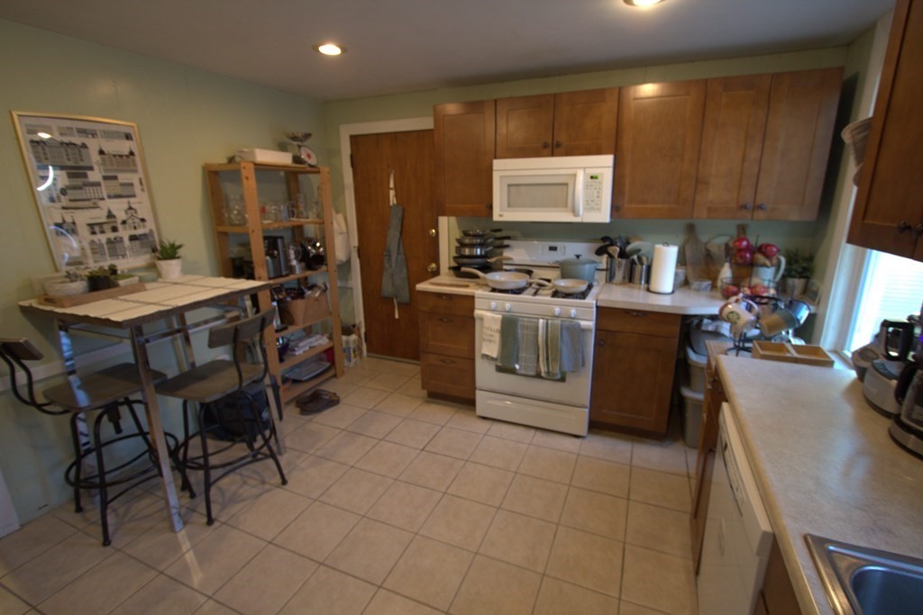 a kitchen with stainless steel appliances kitchen island granite countertop a sink a stove a dining table and chairs