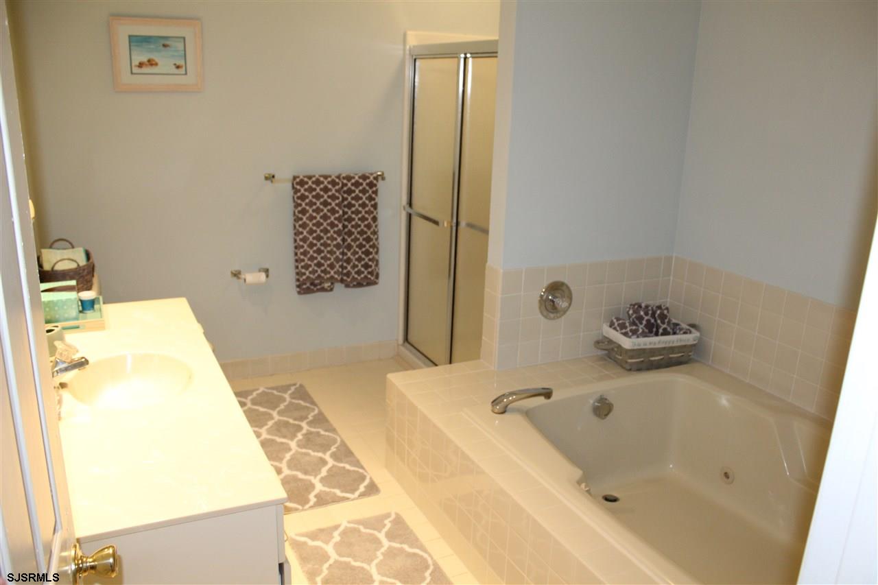 1101 East Shore Drive, Unit C Brigantine, NJ 08203 - Photo 14 of 22 a bathroom with a tub sink and mirror
