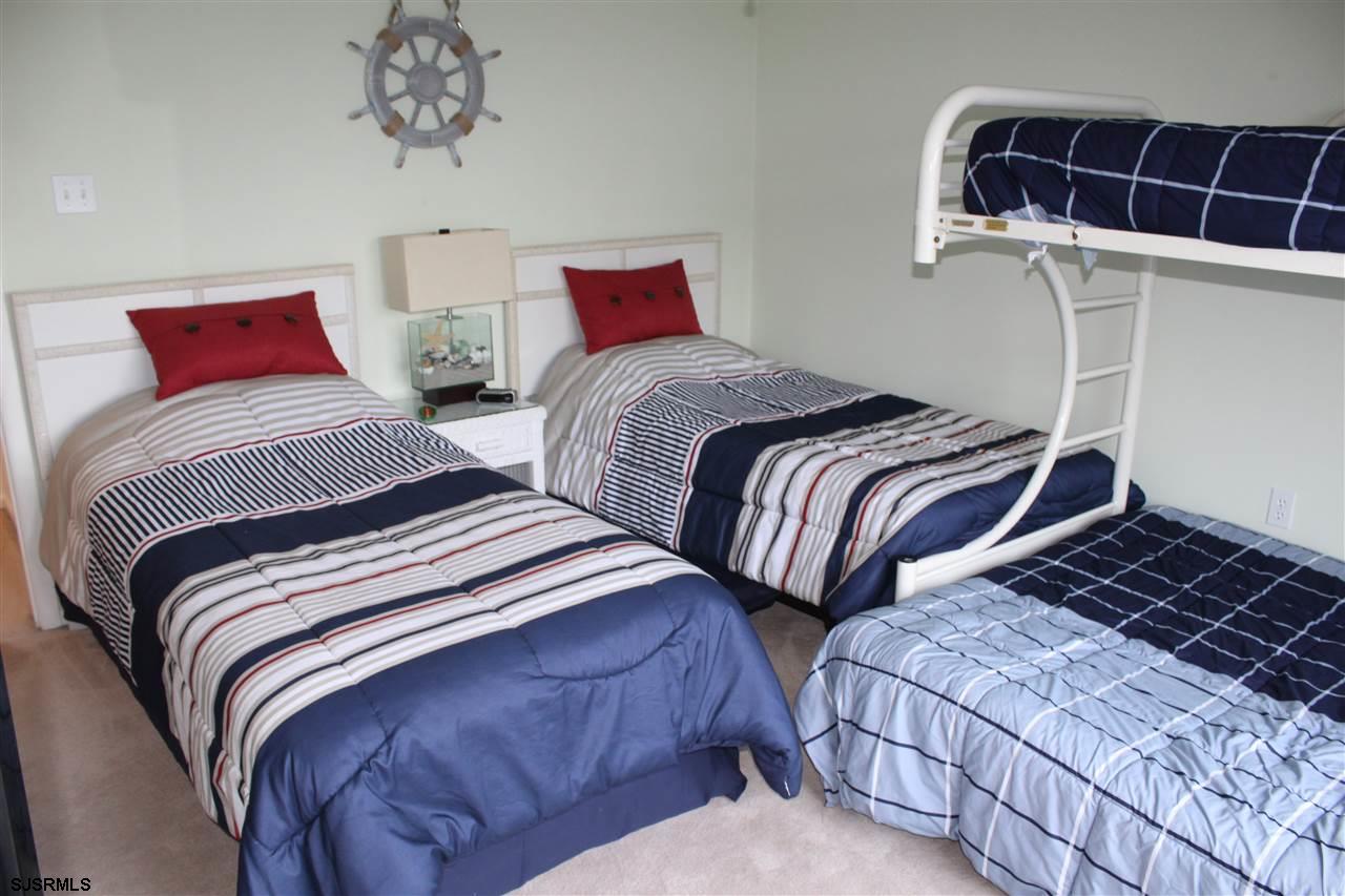 1101 East Shore Drive, Unit C Brigantine, NJ 08203 - Photo 16 of 22 a bedroom with two beds and a chandelier