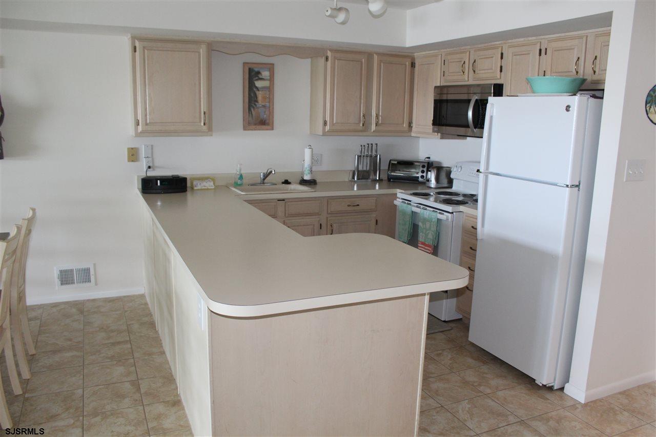 1101 East Shore Drive, Unit C Brigantine, NJ 08203 - Photo 22 of 22 a white refrigerator freezer sitting inside of a kitchen