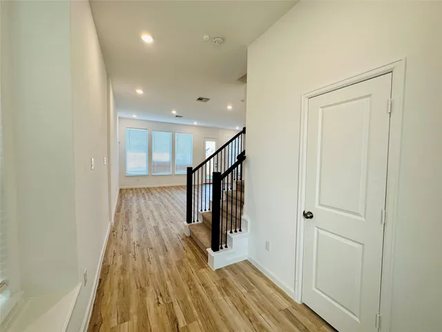 a view of a hallway with wooden floor and staircase