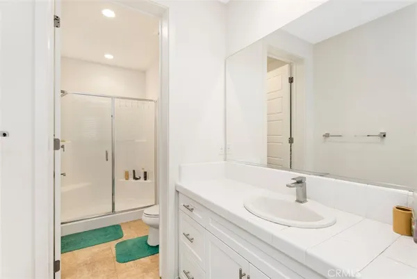 a bathroom with a sink and a mirror with shower