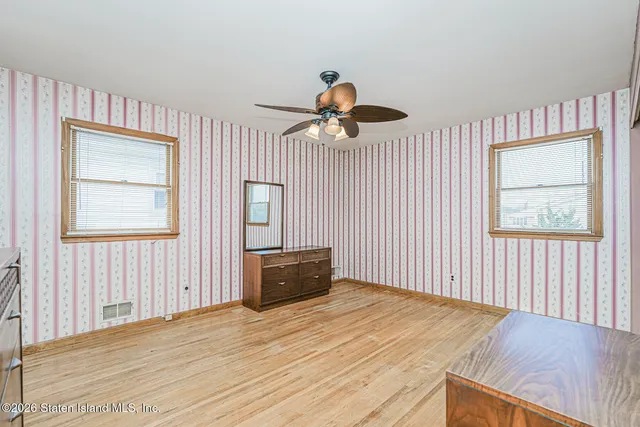 a bedroom with bed and wooden floor