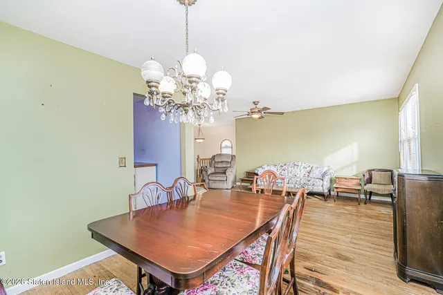 a dining room with furniture a chandelier and wooden floor