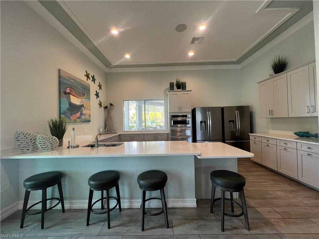 28442 Captiva Shell Loop Bonita Springs, FL 34135 - Photo 29 of 35 a large kitchen with dining table and chairs