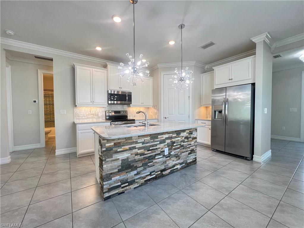 28442 Captiva Shell Loop Bonita Springs, FL 34135 - Photo 5 of 35 a kitchen with stainless steel appliances kitchen island granite countertop a refrigerator a stove a microwave and a sink