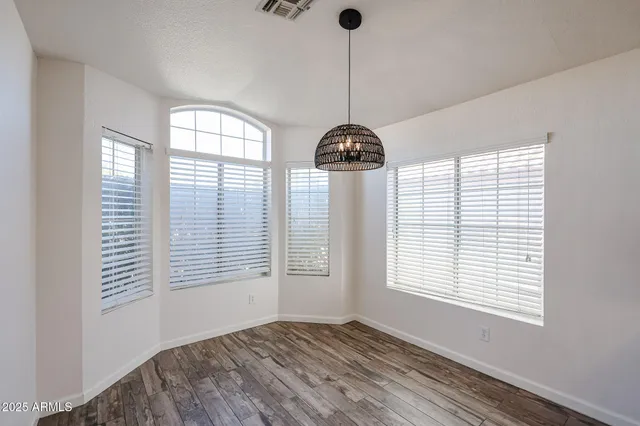 a large white kitchen with a large window a oven and stainless steel appliances