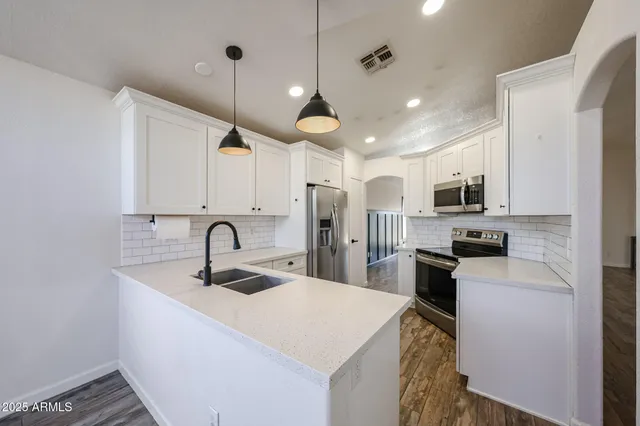a kitchen with white cabinets and appliances