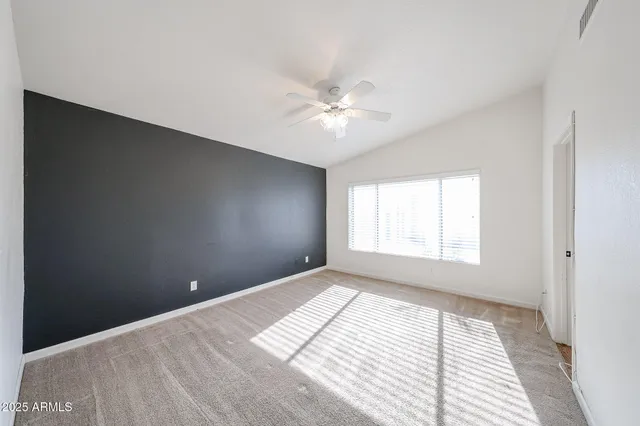 a bedroom with a bed and a chandelier fan