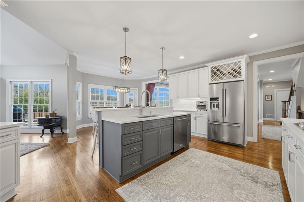 140 Red Gate Lakes Drive Canton, GA 30115 - Photo 29 of 92 a kitchen with stainless steel appliances kitchen island granite countertop a refrigerator a oven a stove and a dining table with wooden floor