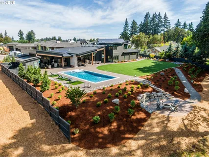 a view of a swimming pool with lawn chairs and a yard