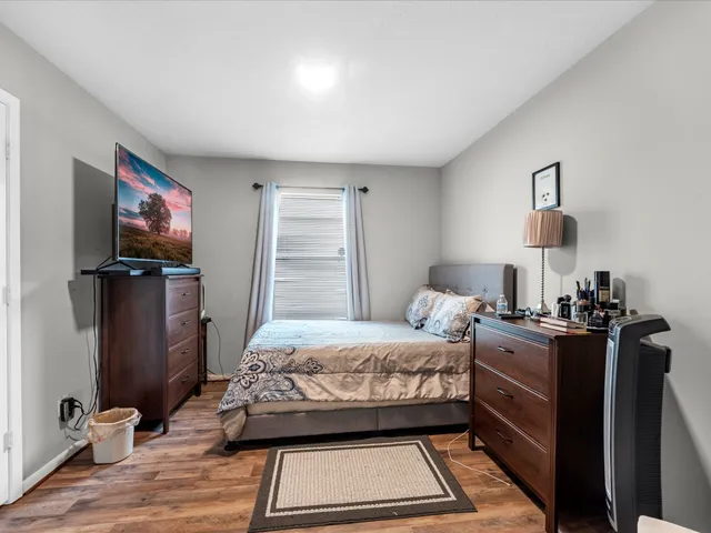 a bedroom with a bed and a flat tv screen on a dresser