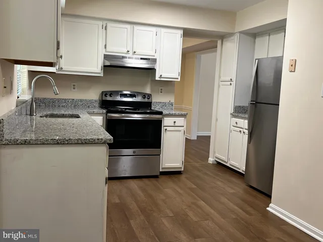 a kitchen with stainless steel appliances granite countertop a refrigerator sink and stove