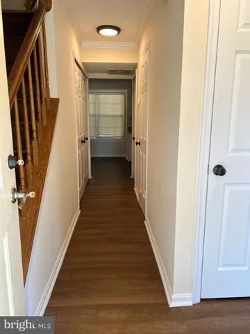 a view of a hallway with wooden floor and staircase