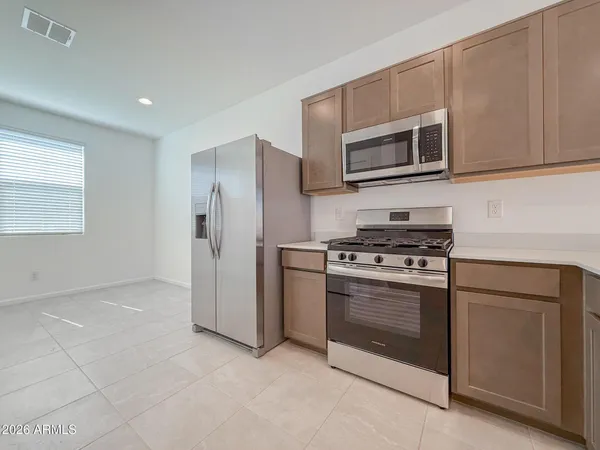 a kitchen with stainless steel appliances granite countertop a stove a microwave and a refrigerator