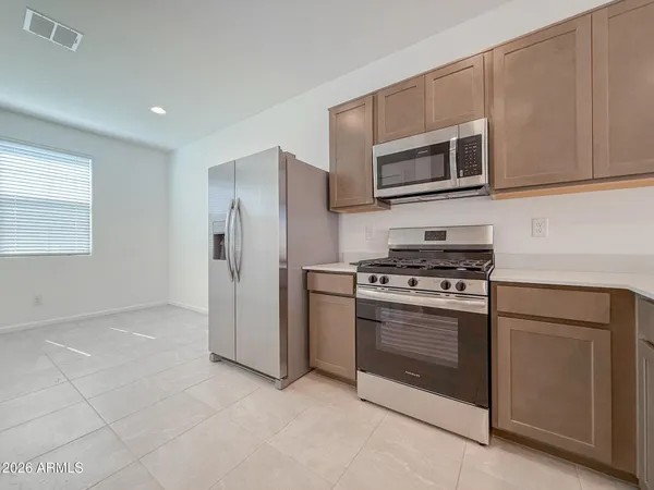a kitchen with stainless steel appliances granite countertop a stove a microwave and a refrigerator