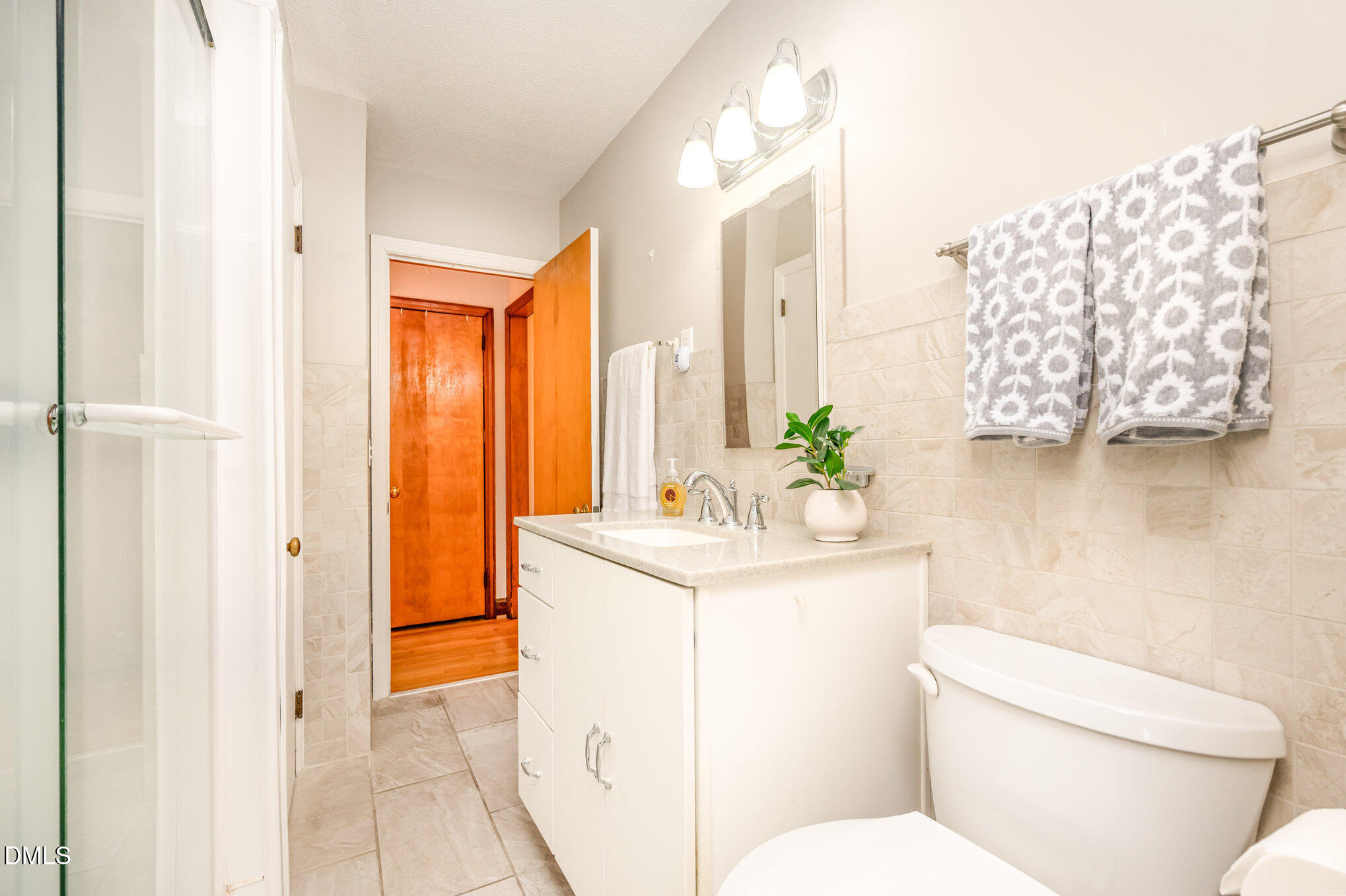 3845 Marsh Creek Road Raleigh, NC 27604 - Photo 13 of 24 a bathroom with a sink a toilet and shower curtain