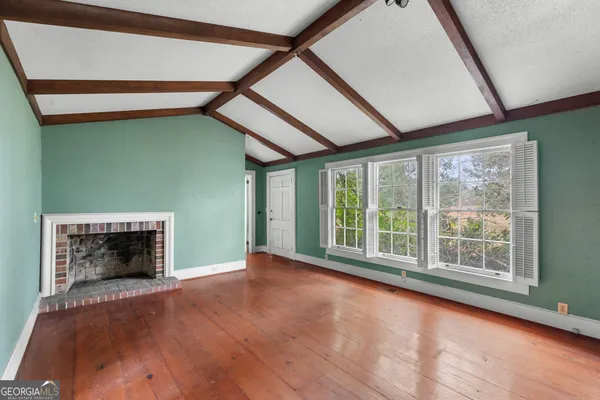 a view of an empty room with a fireplace and a window
