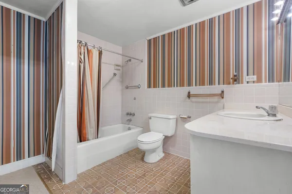 a bathroom with a sink a toilet and shower curtain