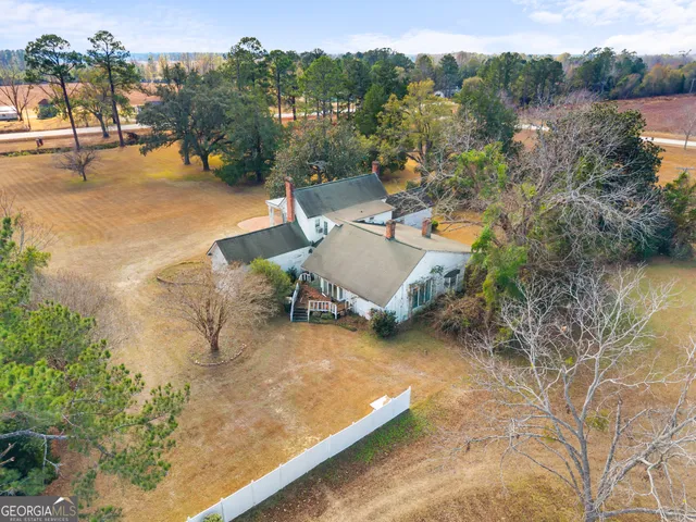 an aerial view of a house with yard and lake view
