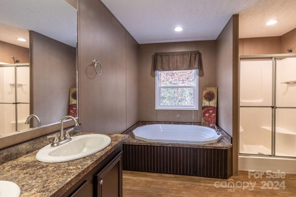 572 Dark Ridge Road Sylva, NC 28779 - Photo 11 of 26 a bathroom with a granite countertop sink a mirror and a bathtub