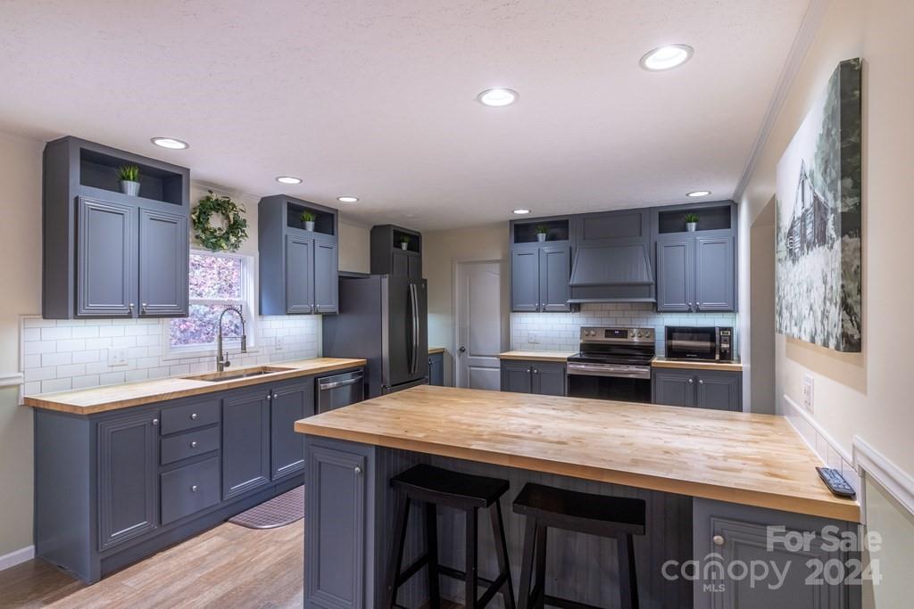 572 Dark Ridge Road Sylva, NC 28779 - Photo 15 of 26 a kitchen with stainless steel appliances granite countertop a sink and wooden cabinets