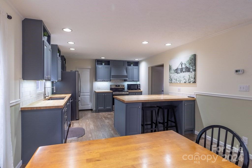 572 Dark Ridge Road Sylva, NC 28779 - Photo 26 of 26 a kitchen with stainless steel appliances granite countertop a sink a stove a refrigerator cabinets and a dining table