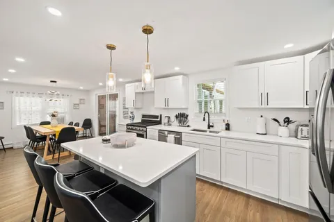 a kitchen with a dining table chairs sink and cabinets