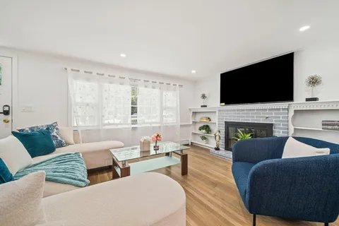 a living room with furniture a fireplace and a flat screen tv