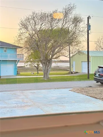 a view of a house with a yard and a large trees