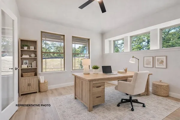 a view of a workspace with furniture and a window