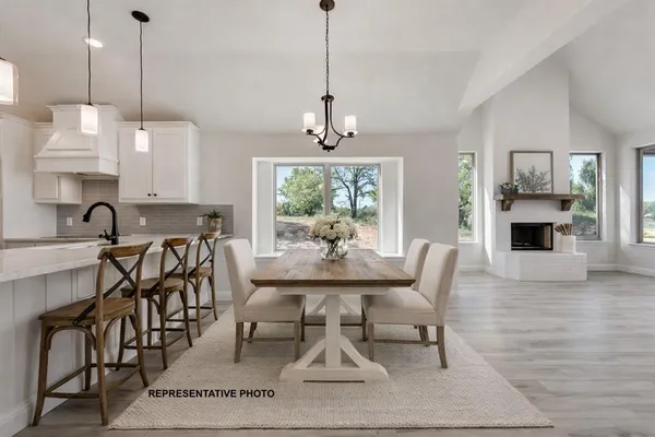 a dining room with furniture a chandelier and wooden floor