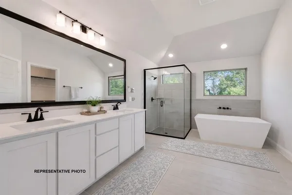 a bathroom with a double vanity sink mirror and bathtub