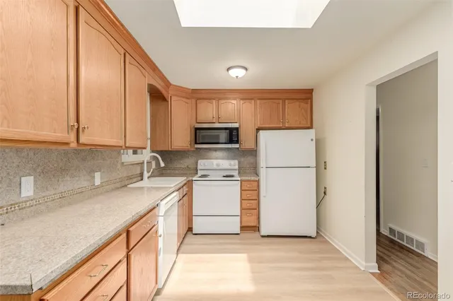 a kitchen with stainless steel appliances granite countertop a refrigerator sink and stove