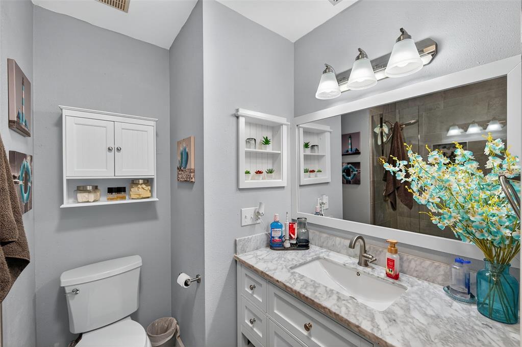 1993 Citrus Hill Road Palm Harbor, FL 34683 - Photo 15 of 37 a bathroom with a granite countertop sink vanity mirror and toilet