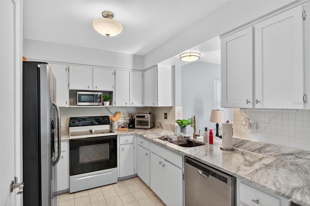 1993 Citrus Hill Road Palm Harbor, FL 34683 - Photo 24 of 37 a kitchen with stainless steel appliances granite countertop a sink a stove a refrigerator a stove and cabinets