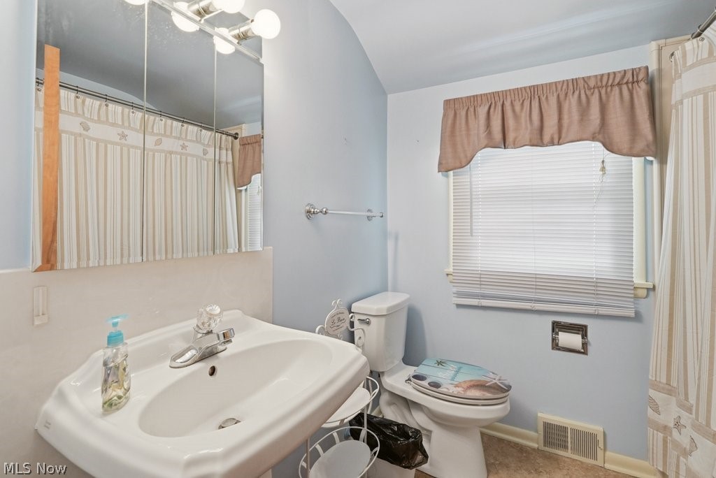 161 Pinehurst Road Munroe Falls, OH 44262 - Photo 25 of 40 Bathroom featuring a pedestal sink, a wall-mounted medicine cabinet with integrated lighting, a window with blinds, and a shower with a patterned curtain