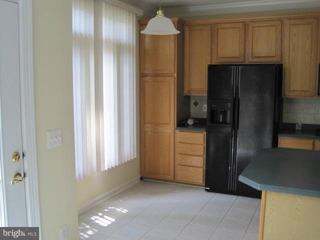 4908 Waple Lane Alexandria, VA 22304 - Photo 10 of 23 a view of a refrigerator in kitchen and an empty room with wooden floor windows