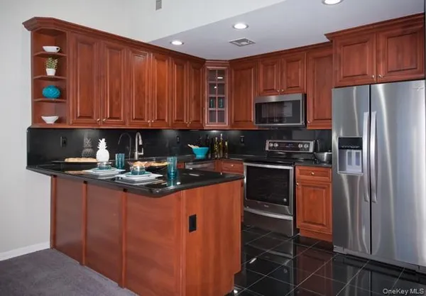 a kitchen with stainless steel appliances granite countertop a stove refrigerator sink and cabinets