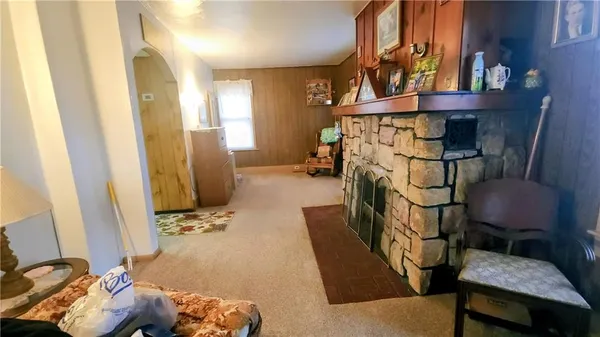 a living room with a bed and a dresser next to a window