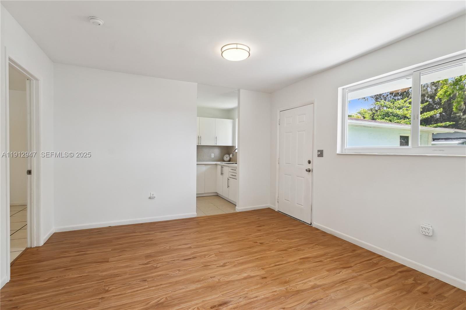 793 Northwest 91st Street, Unit 2 Miami, FL 33150 - Photo 2 of 9 a view of empty room with wooden floor and fan