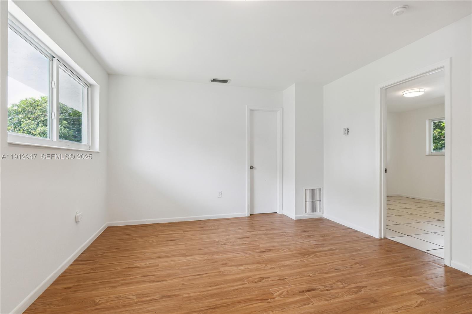 793 Northwest 91st Street, Unit 2 Miami, FL 33150 - Photo 3 of 9 a view of empty room with wooden floor and fan