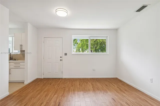 an empty room with a hardwood and a window