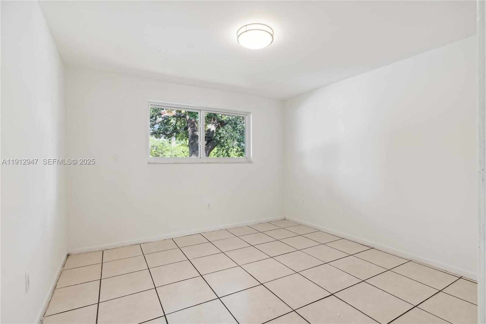 793 Northwest 91st Street, Unit 2 Miami, FL 33150 - Photo 7 of 9 a view of an empty room and window