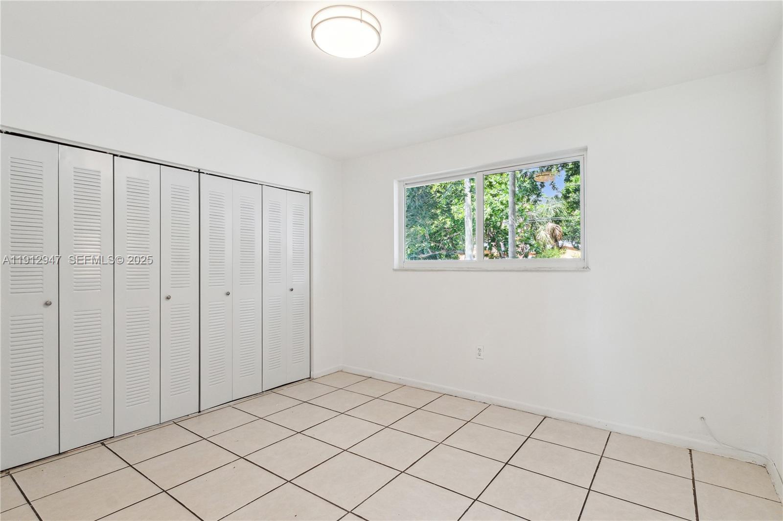 793 Northwest 91st Street, Unit 2 Miami, FL 33150 - Photo 8 of 9 a view of an empty room and window