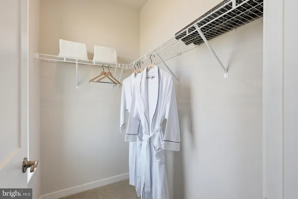 a view of walk in closet with clothes